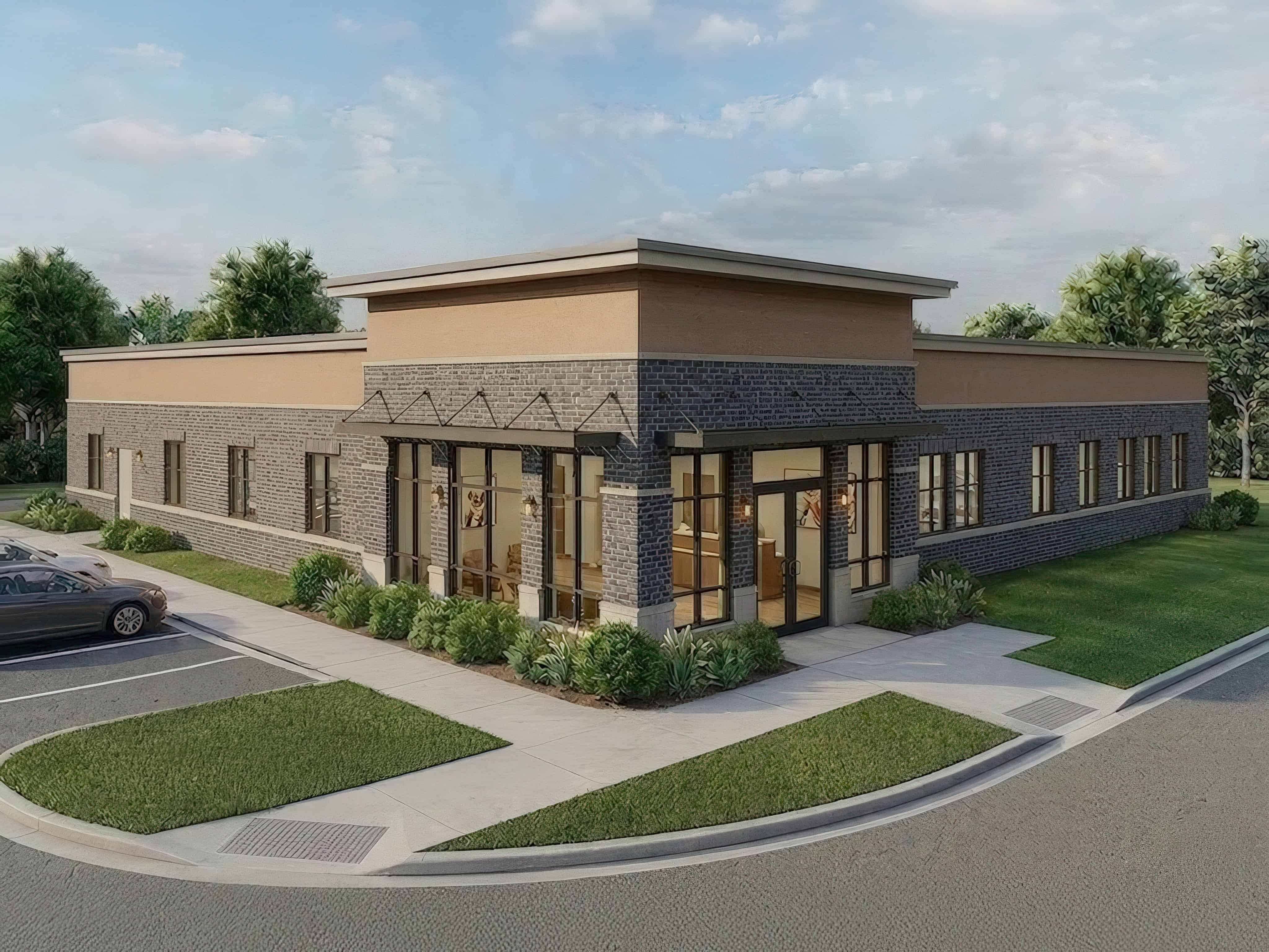 Modern commercial building with brick and stone facade, large windows, and landscaped surroundings.