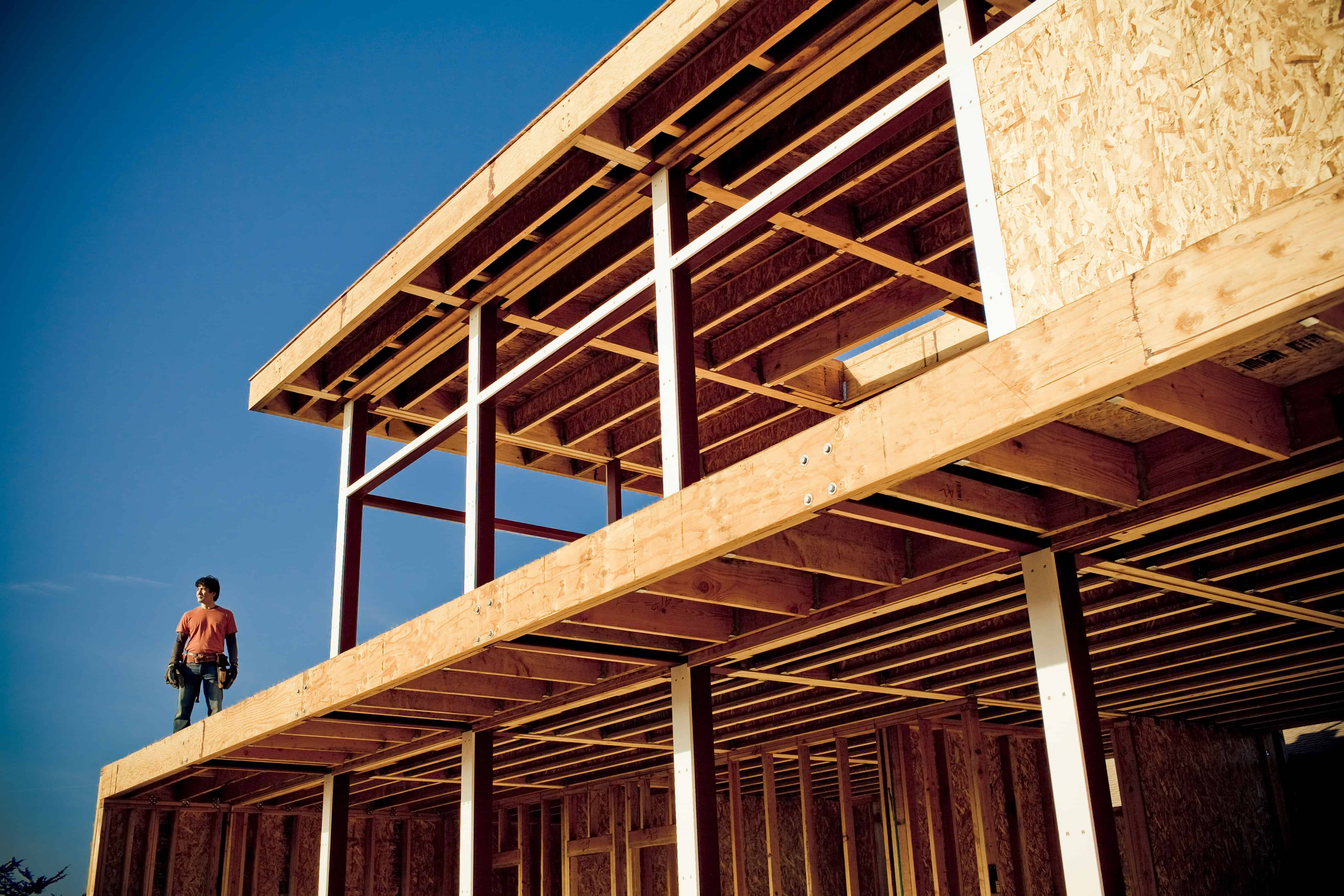 Construction site with wooden framework and a worker on site.