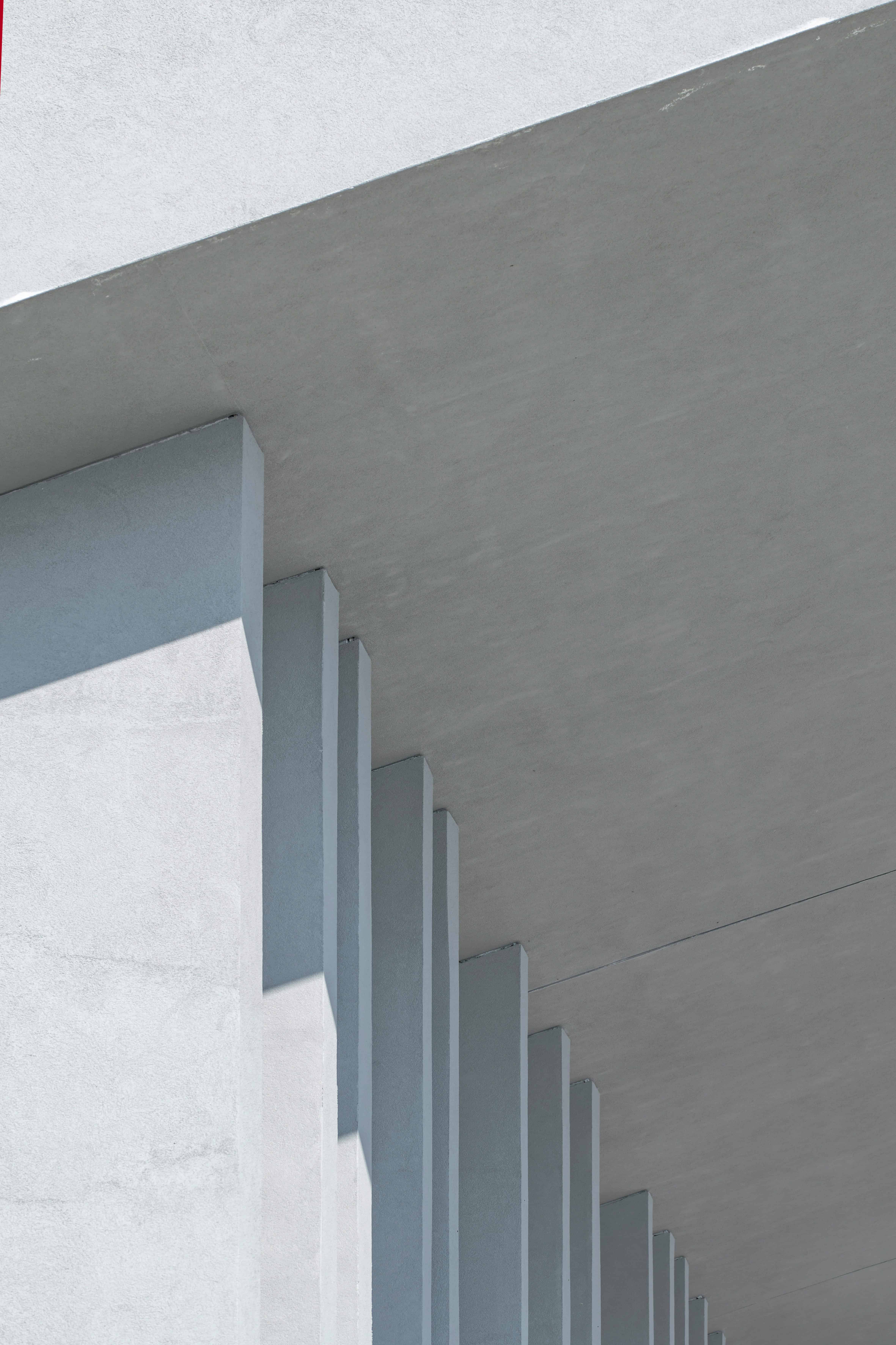 Close-up of modern concrete building with vertical fins and overhang.