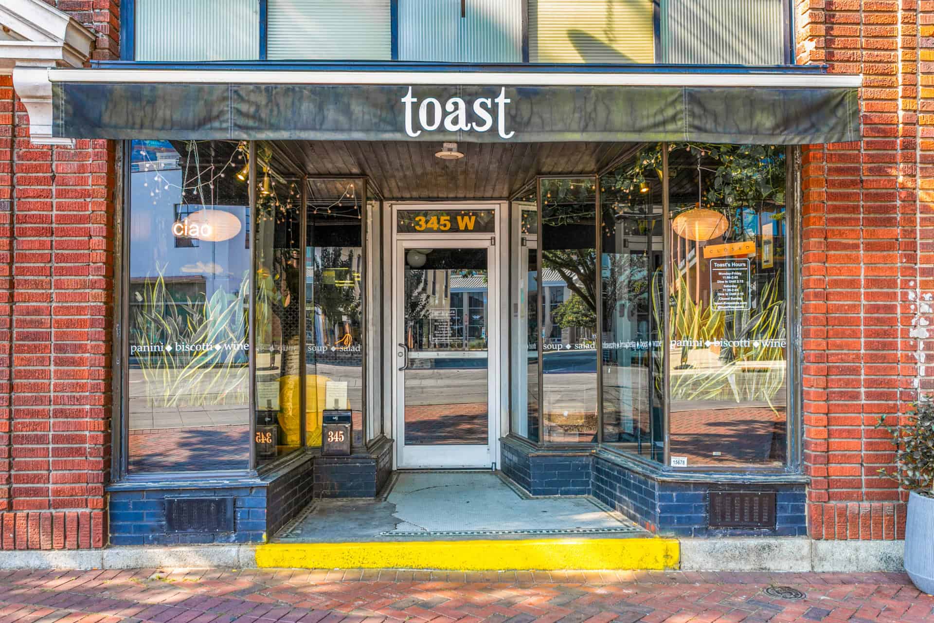 Exterior view of Toast restaurant entrance with signage and brick facade.