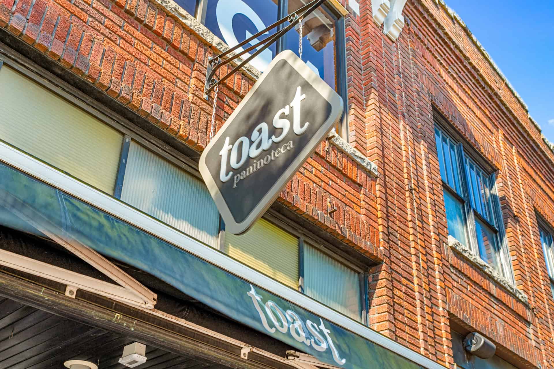 Exterior view of a brick building with a Toast sign for a restaurant.